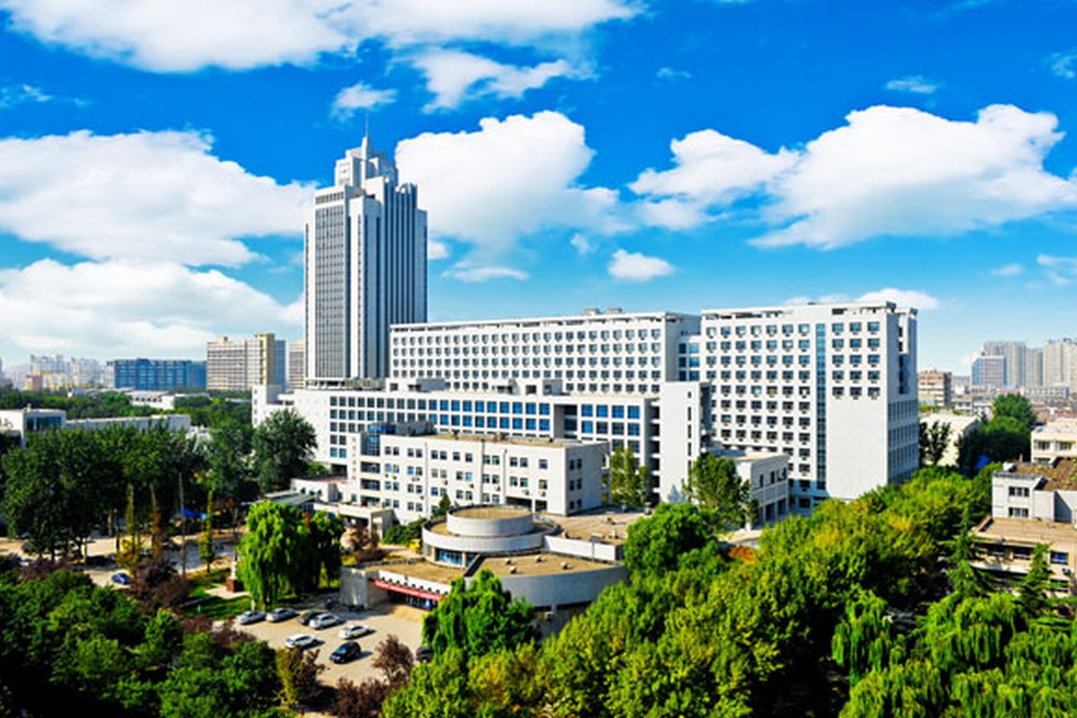 A landscaped campus with trees and modern buildings in clear daylight.
